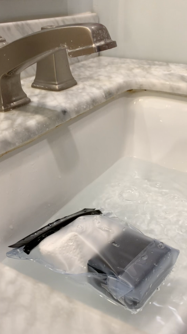 an insulin pump in a waterproof bag in a sink with water