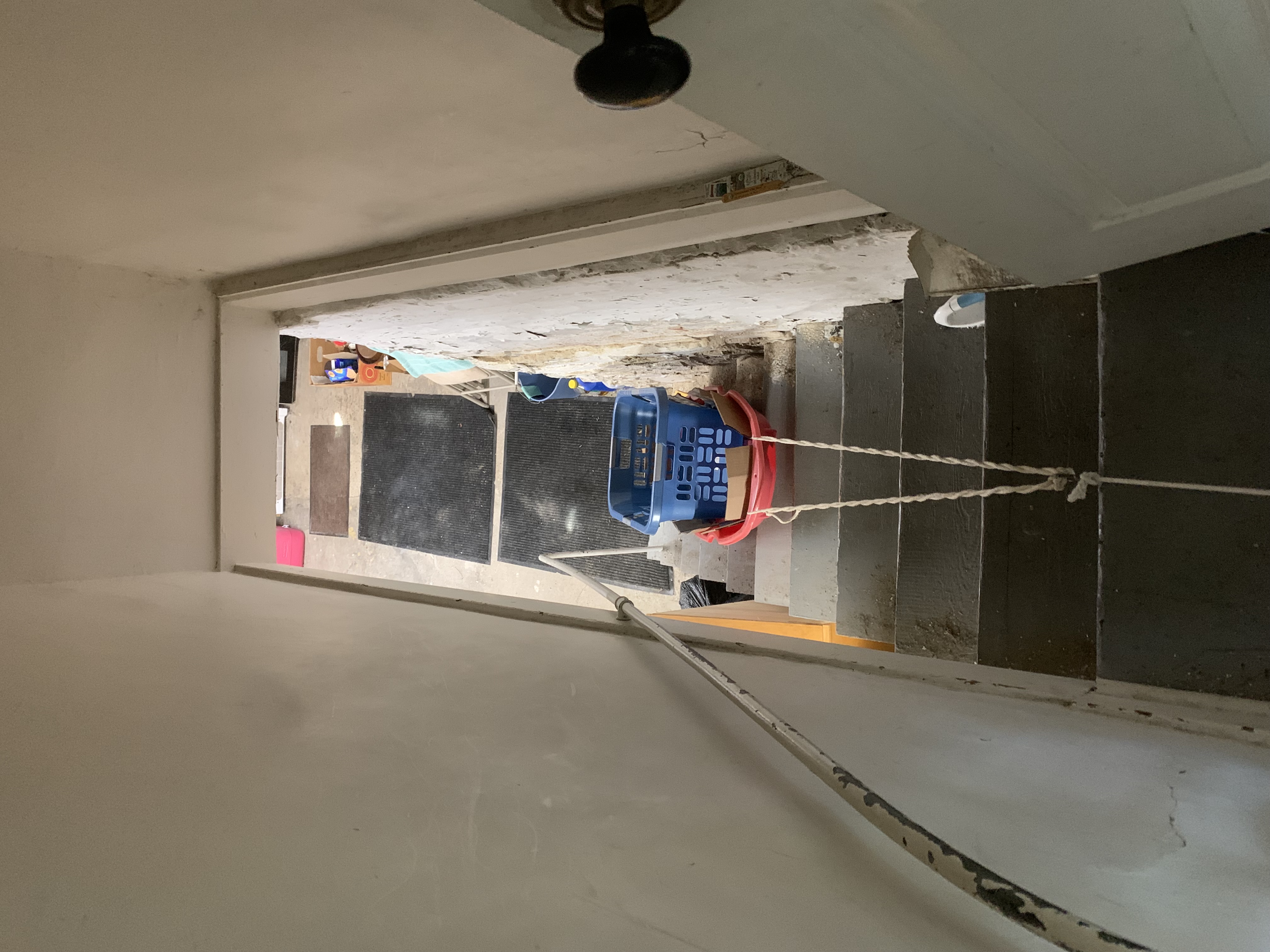 a sled with a laundry basket in it at the top of a set of stairs